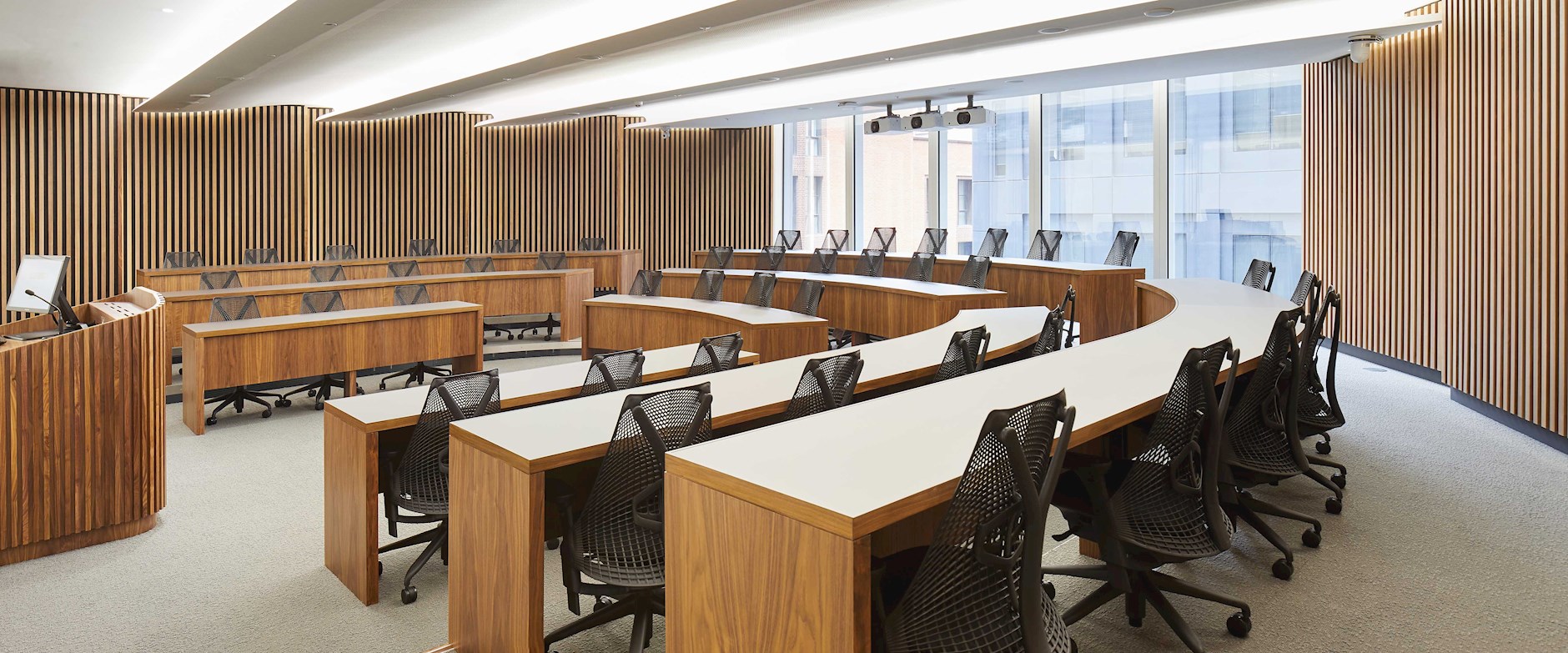 Exec Education classroom with curved desks and black chairs